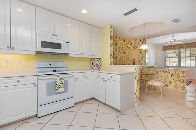 242 Hidden Bay Dr Unit 603, Osprey, FL 34229 - kitchen featuring white appliances, light countertops, white cabinetry, a peninsula, and wallpapered walls