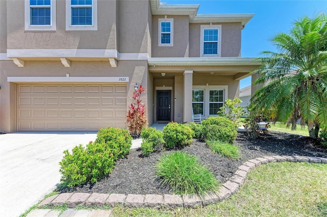 7822 110th Ave E, Parrish, FL 34219 - view of front facade with a porch, driveway, a garage, and stucco siding