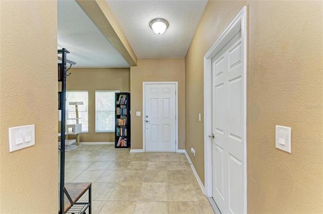 7822 110th Ave E, Parrish, FL 34219 - foyer entrance with a textured ceiling, a textured wall, and baseboards