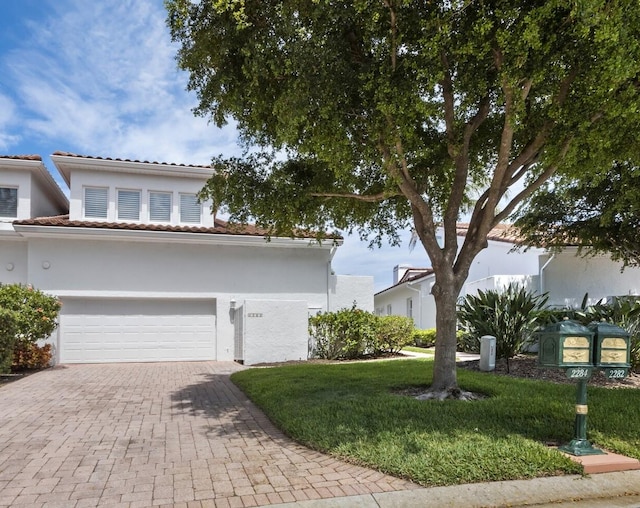 2282 Harbour Court Dr, Longboat Key, FL 34228 - view of front of home featuring a garage, a front lawn, decorative driveway, stucco siding, and a tiled roof