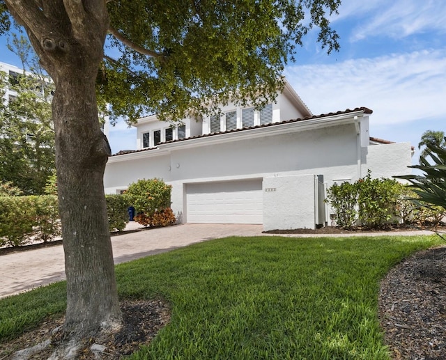 2282 Harbour Court Dr, Longboat Key, FL 34228 - view of front facade featuring a garage, driveway, a front lawn, and stucco siding