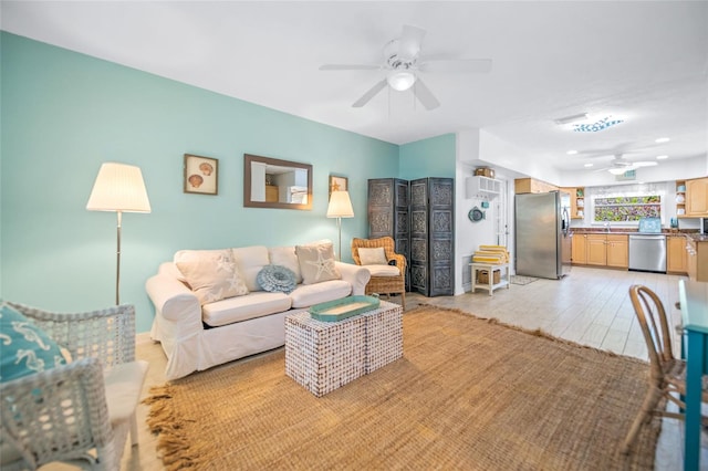 living room featuring a ceiling fan and light wood-type flooring