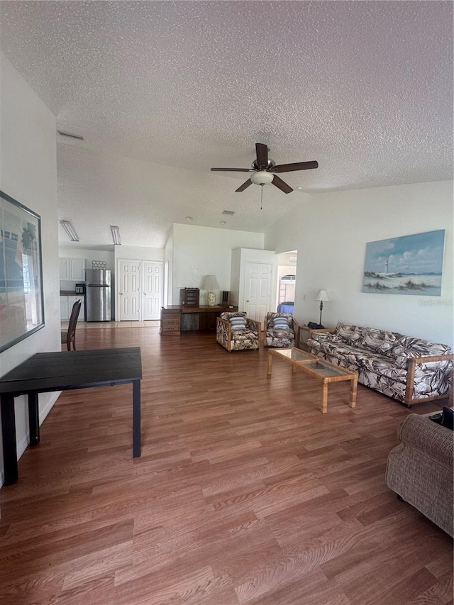 living room with wood finished floors, ceiling fan, and a textured ceiling