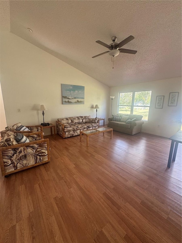 living room with wood finished floors, ceiling fan, a textured ceiling, and lofted ceiling