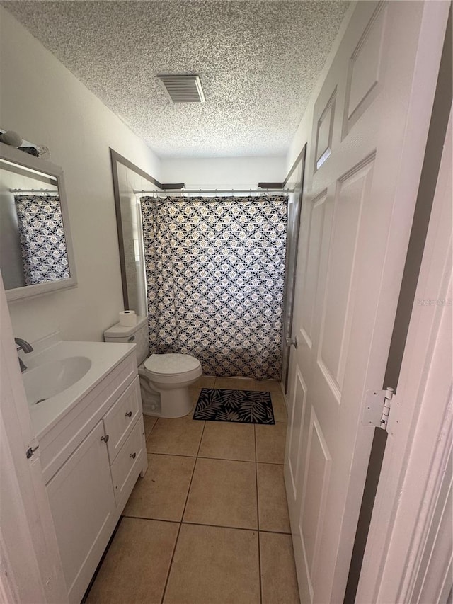 bathroom featuring vanity, curtained shower, tile patterned floors, visible vents, and a textured ceiling