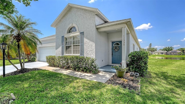 12339 Hollybush Ter, Lakewood Ranch, FL 34202 - view of front of house featuring a garage, stucco siding, and a front lawn