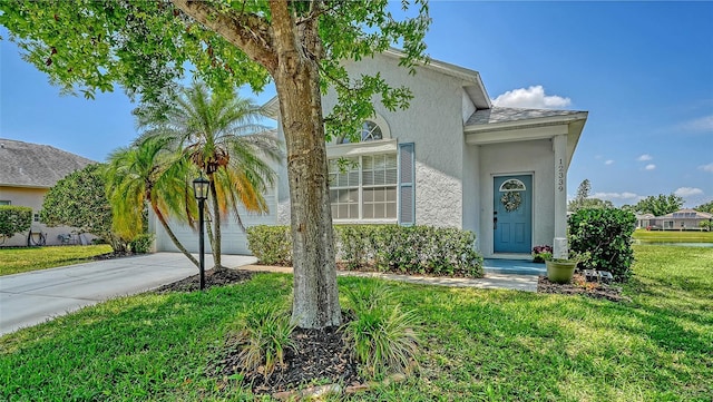 12339 Hollybush Ter, Lakewood Ranch, FL 34202 - view of front of property featuring a front yard, concrete driveway, and stucco siding