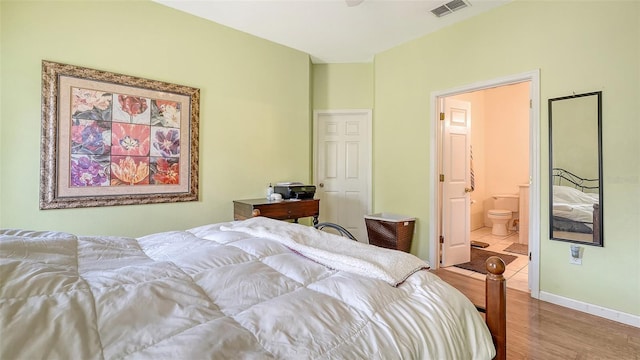 12339 Hollybush Ter, Lakewood Ranch, FL 34202 - bedroom with wood finished floors, ensuite bathroom, and baseboards