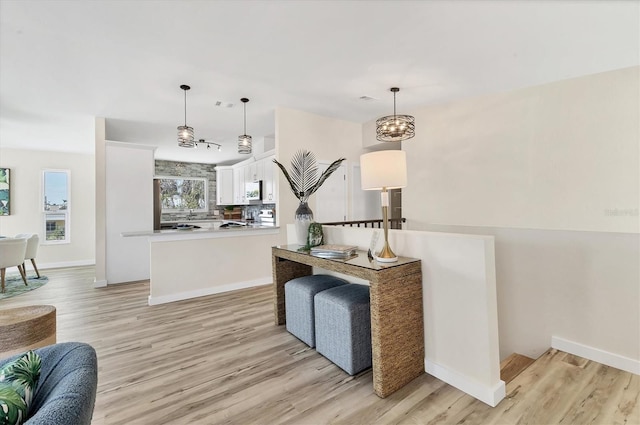 interior space with light wood-style floors, baseboards, and range with electric cooktop
