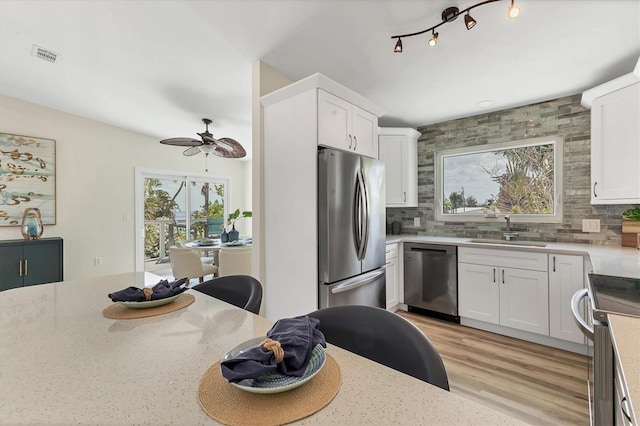 kitchen with visible vents, a sink, decorative backsplash, and stainless steel appliances