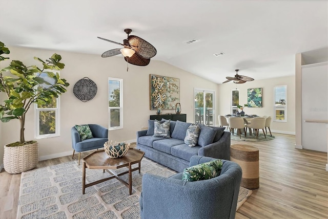 living area featuring light wood-style floors, a ceiling fan, and visible vents
