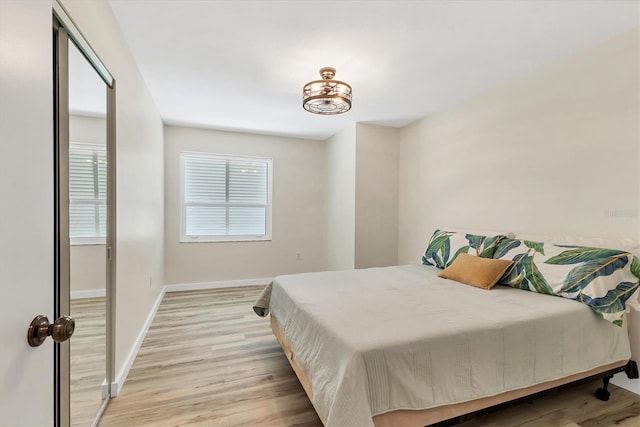 bedroom featuring baseboards and light wood finished floors