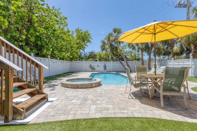 view of pool with a pool with connected hot tub, a fenced backyard, and a patio area