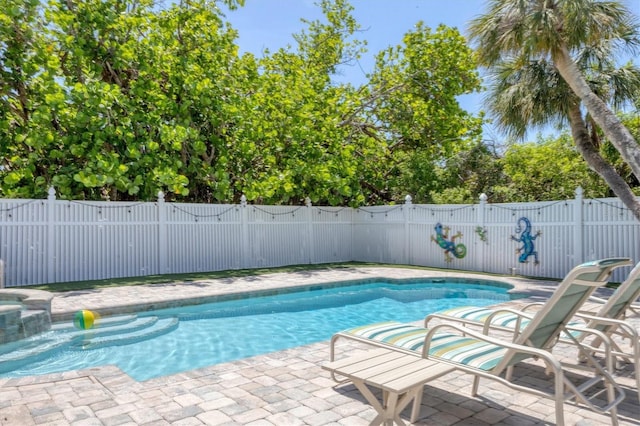 view of swimming pool with fence, a pool with connected hot tub, and a patio area