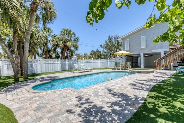 view of pool with ceiling fan, a patio, a fenced backyard, stairs, and a pool with connected hot tub