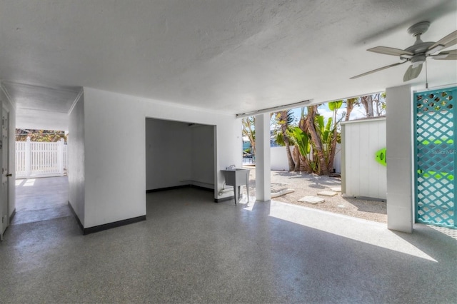 interior space featuring fence and a ceiling fan