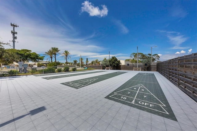 view of home's community with shuffleboard and fence