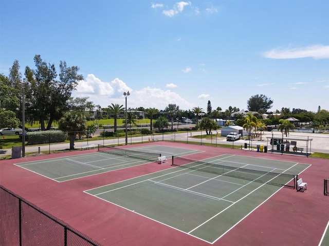 view of tennis court featuring fence and community basketball court