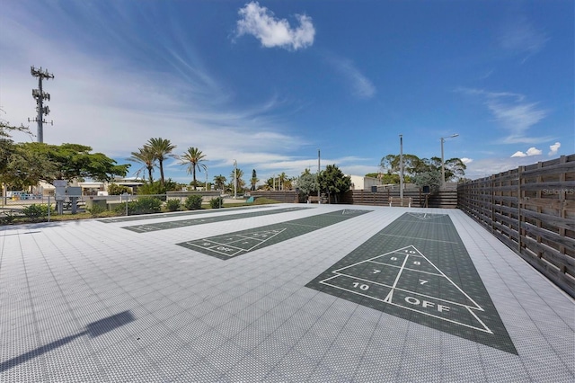 surrounding community featuring shuffleboard and fence