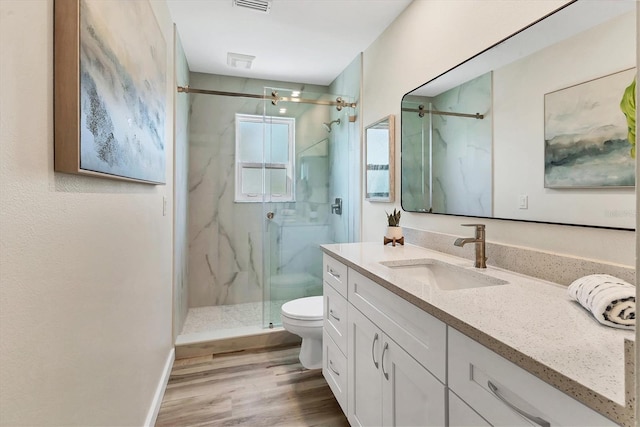 501 Key Royale Dr, Holmes Beach, FL 34217 - bathroom featuring toilet, vanity, a marble finish shower, wood finished floors, and baseboards