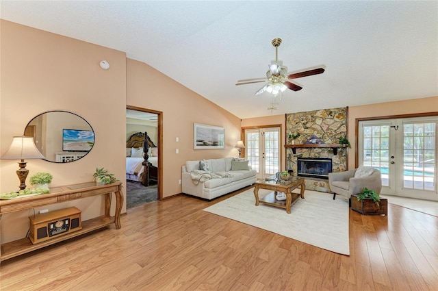 living room with french doors, a ceiling fan, light wood finished floors, and lofted ceiling