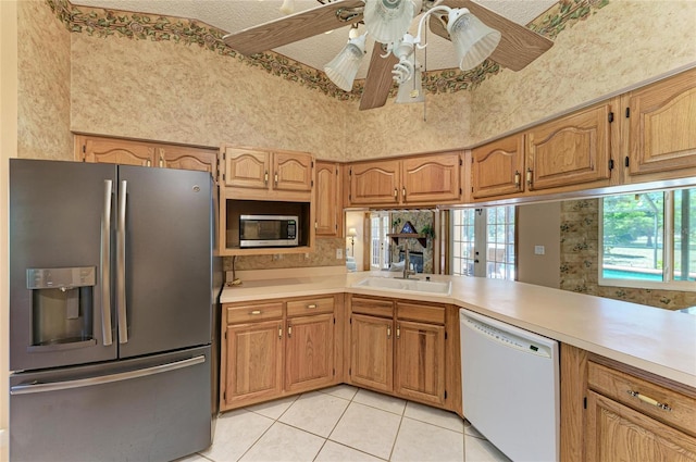 kitchen featuring light countertops, a sink, light tile patterned floors, and stainless steel appliances