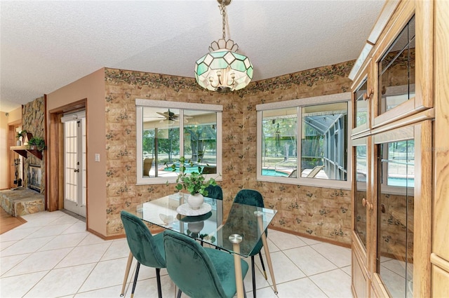 dining space featuring baseboards, light tile patterned flooring, and a textured ceiling