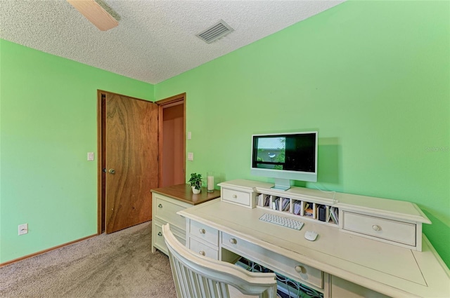 office space with visible vents, a textured ceiling, and light colored carpet