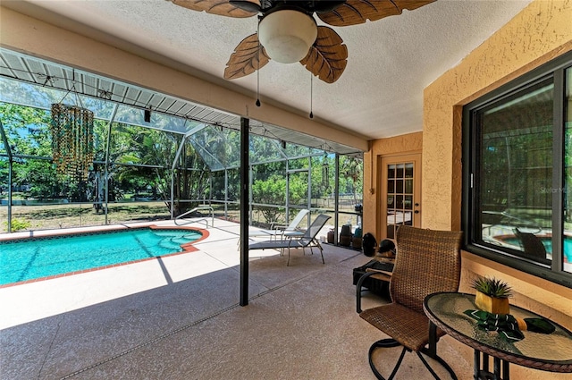 pool featuring a patio, ceiling fan, and glass enclosure