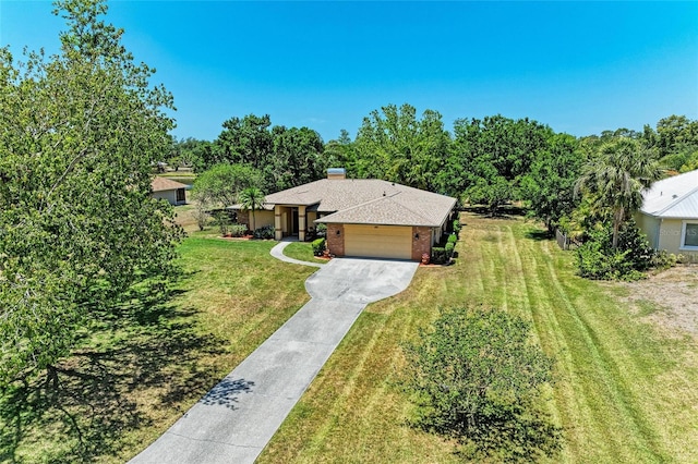 view of front of property featuring brick siding, driveway, a front lawn, and a garage