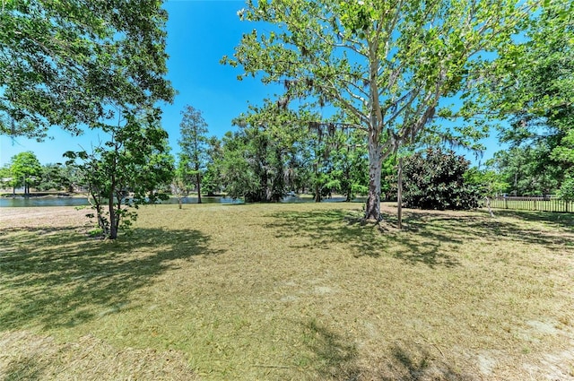 view of yard featuring a water view and fence
