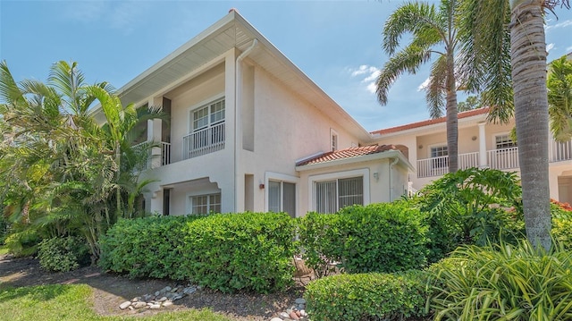 4264 Central Sarasota Pkwy Unit 111, Sarasota, FL 34238 - view of side of home with stucco siding, a tiled roof, and a balcony