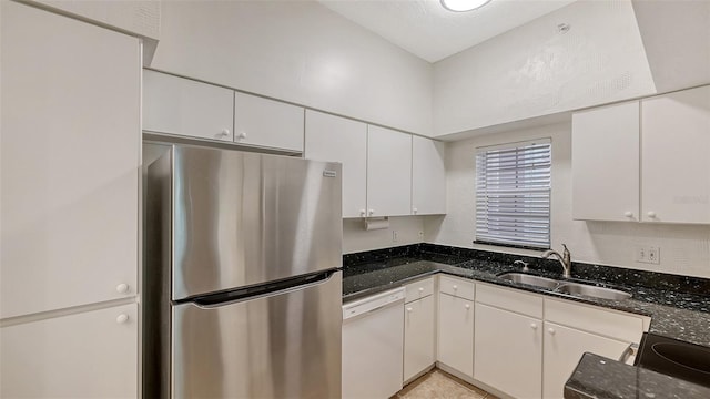 4264 Central Sarasota Pkwy Unit 111, Sarasota, FL 34238 - kitchen with freestanding refrigerator, white dishwasher, a sink, white cabinetry, and dark stone countertops