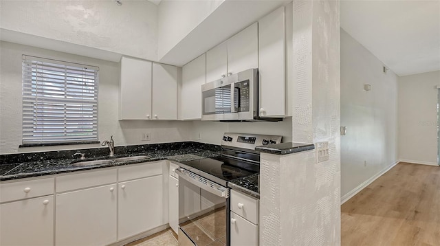 4264 Central Sarasota Pkwy Unit 111, Sarasota, FL 34238 - kitchen with appliances with stainless steel finishes, a sink, white cabinetry, light wood finished floors, and baseboards