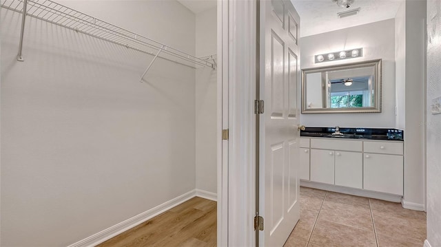 4264 Central Sarasota Pkwy Unit 111, Sarasota, FL 34238 - bathroom with vanity, baseboards, and a spacious closet