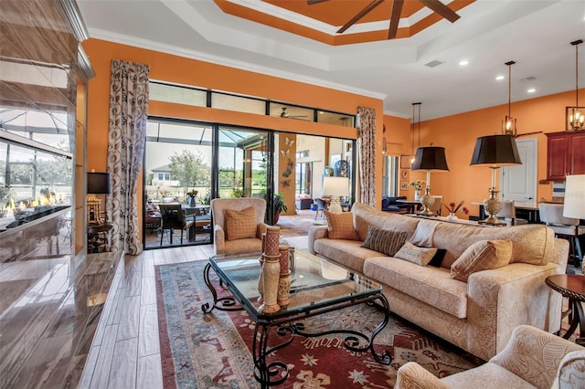 living area featuring ornamental molding, recessed lighting, and a tray ceiling