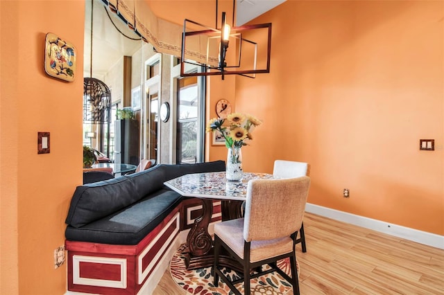 dining room with wood finished floors, a chandelier, and baseboards