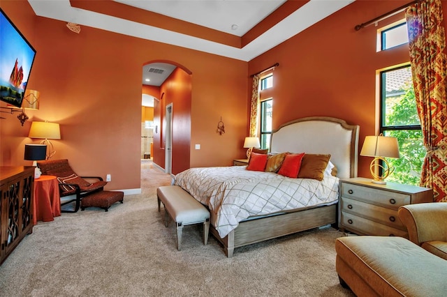 bedroom featuring arched walkways, carpet flooring, and baseboards
