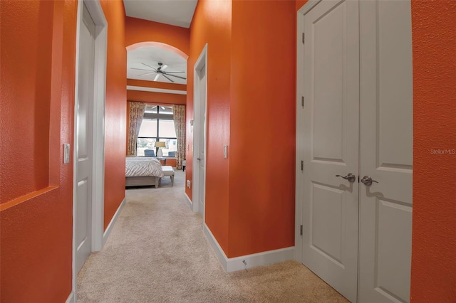 corridor with light carpet and baseboards