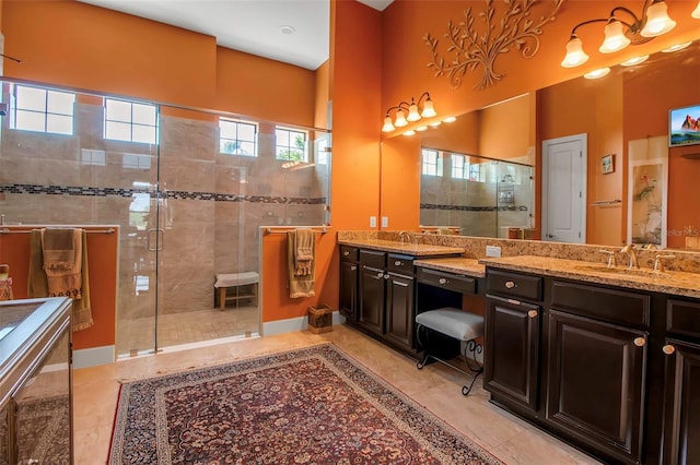 full bath with a stall shower, vanity, and baseboards