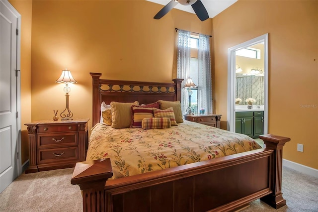 bedroom with light carpet, ensuite bath, baseboards, and ceiling fan