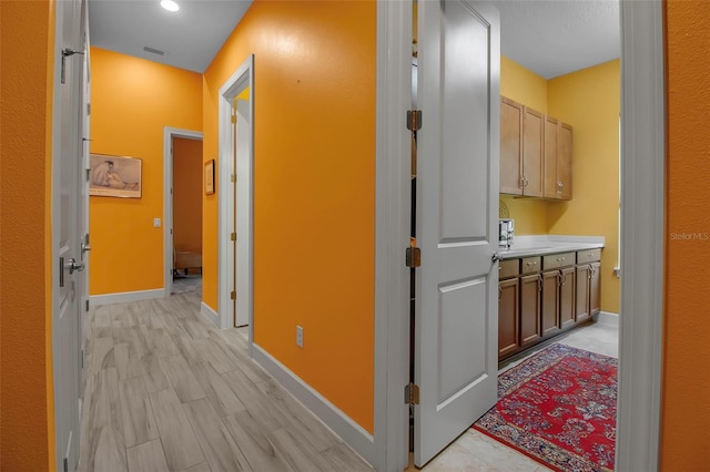 corridor featuring baseboards and recessed lighting