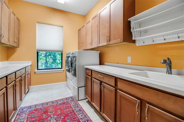 clothes washing area with cabinet space, washing machine and dryer, and baseboards