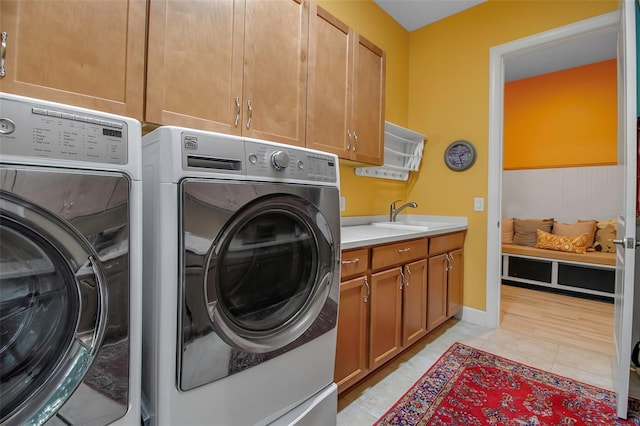 laundry area with cabinet space, independent washer and dryer, and light tile patterned flooring