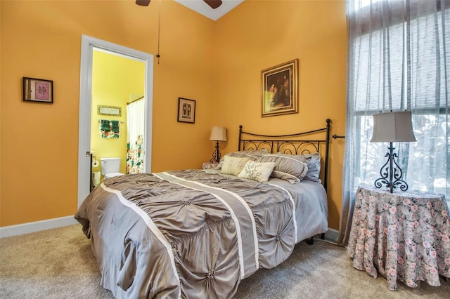 carpeted bedroom with baseboards, ensuite bath, and ceiling fan