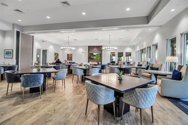 dining room featuring healthy amount of natural light, light wood finished floors, a chandelier, and recessed lighting