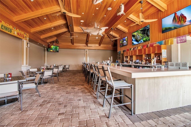 miscellaneous room featuring wooden ceiling, brick floors, a ceiling fan, high vaulted ceiling, and beamed ceiling