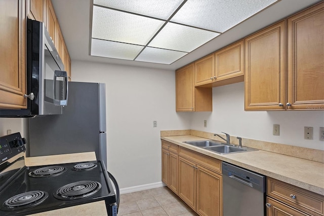 5800 Hollywood Blvd Unit 312, Sarasota, FL 34231 - kitchen featuring a sink, stainless steel appliances, light tile patterned flooring, light countertops, and baseboards