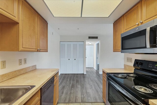 5800 Hollywood Blvd Unit 312, Sarasota, FL 34231 - kitchen featuring black electric range oven, dishwasher, visible vents, stainless steel microwave, and light countertops