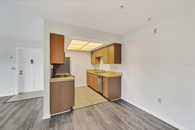5800 Hollywood Blvd Unit 312, Sarasota, FL 34231 - kitchen featuring a sink, light wood-style flooring, light countertops, stainless steel dishwasher, and baseboards